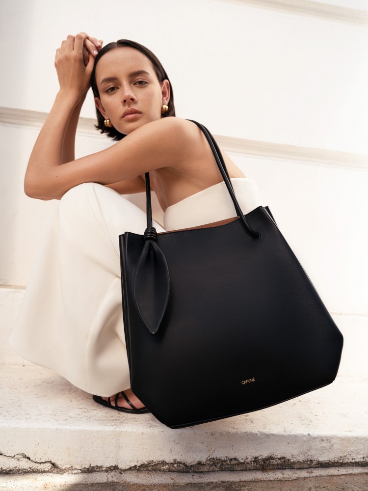 2025秋冬新作「Ori Tote」，靈感取自日本摺紙藝術，包身以幾何廓形描繪立體層次，兩側摺褶細節呼應折紙的俐落節奏，管狀手柄與葉形結飾增添自然韻律