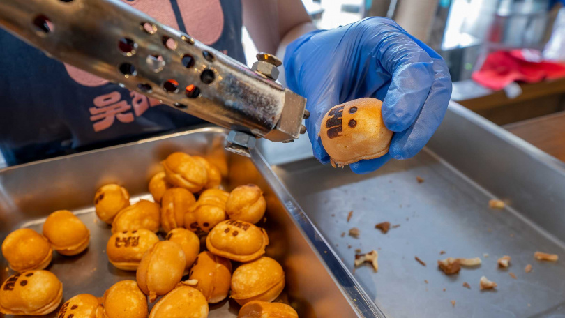 吳甜WuSweets店員幫蜂蜜蛋糕燒烙印上可愛表情，每日可加購搭配的抹醬共有兩種，有草莓、巧克力、鐵觀音等口味輪替。（圖／焦正德攝）