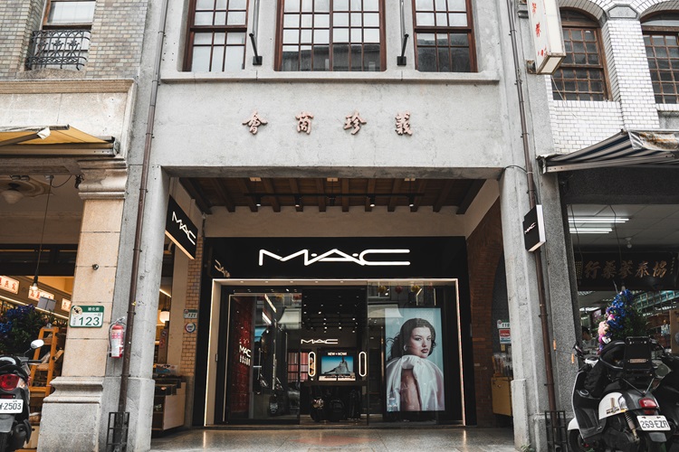 品牌保留三進式街屋的原始格局，活用唭哩岸石條、洗石子、砌牆與天井等建築語彙，並以經典色號Ruby Woo重新詮釋花磚與紅磚牆，使空間呈現前衛與老台北文脈交融的獨特風景。