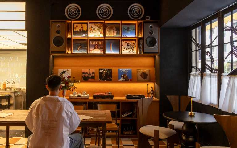 內用區除了適合2～4人的座位還有一共享長桌，黑膠牆同樣充滿歐風元素。（圖／楊澍攝）