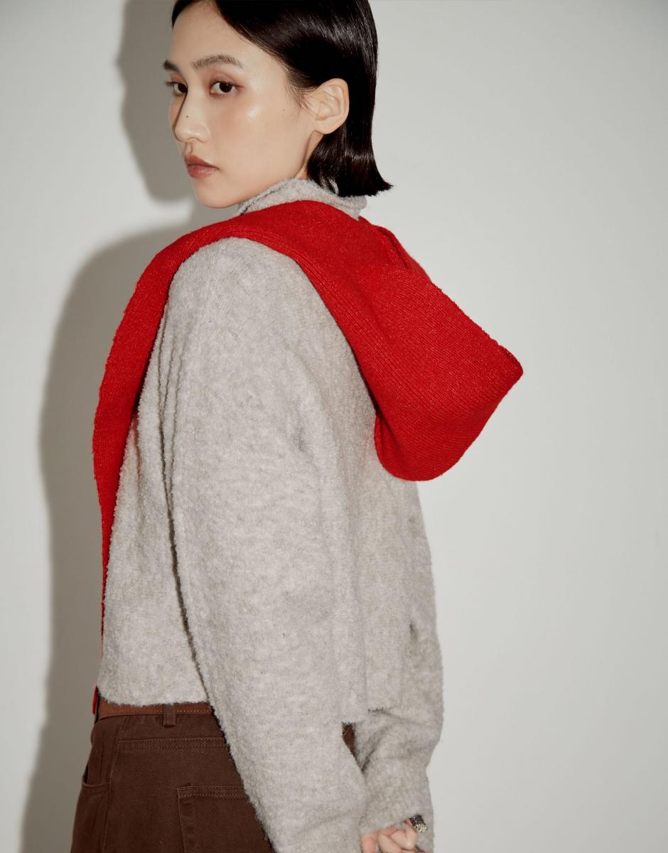 Pazzo 的磨毛感針織連帽圍巾，主打舒適與日常實穿。版型不過於誇張，能自然融入多數冬季造型。磨毛處理讓面料觸感柔軟，貼近肌膚時不易產生刺激感。材質中加入少量羊毛與彈性纖維，使圍巾在保暖之餘仍保有彈性。連帽設計為整體增加層次感，無論搭配長版大衣或短外套，都能形成自然過渡。這款圍巾適合偏好低調造型，但希望在細節中帶出新年氣氛的人。