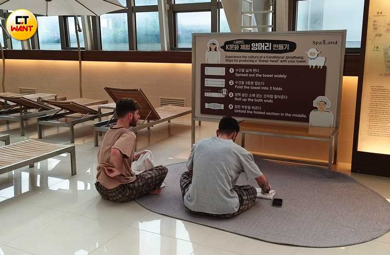 外國觀光客學著 Spa Land 圖示用毛巾綁起汗蒸幕必戴的綿羊頭。 （圖／魏妤靜攝）