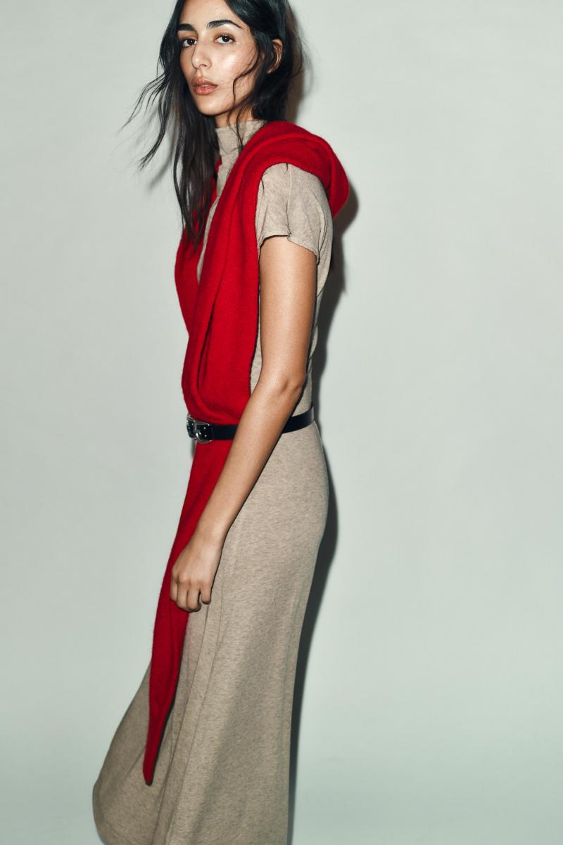 Zara 這款袖子設計圍巾，成功模糊了圍巾與披肩之間的界線。透過袖口結構，讓佩戴時不必反覆調整位置，也能自然固定於肩線上。羊毛混紡材質使面料在保暖與輕盈之間取得平衡，長時間佩戴也不顯厚重。紅色調偏向飽和而不刺眼，適合搭配大地色、米白色或深灰色外套，為冬日造型注入節慶亮點。對於不擅長圍巾層次變化的人來說，這款設計提供了一種相對直覺、好上手的解法。