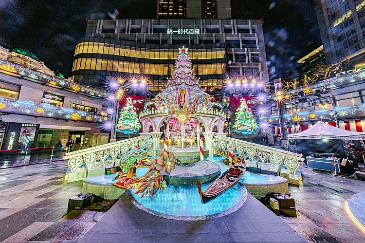 每年同樣備受矚目的統一時代百貨，這次也在二樓夢廣場打造「威尼斯」主題的浪漫場景，高達 13 公尺的主樹以紫光與金色線條營造優雅氛圍，周邊結合義大利水都風情打造總督宮、拱橋、水道與貢多拉船造景，夜晚還有水幕燈光秀與飄雪效果，讓整個空間在夜色中更添夢幻氛圍。