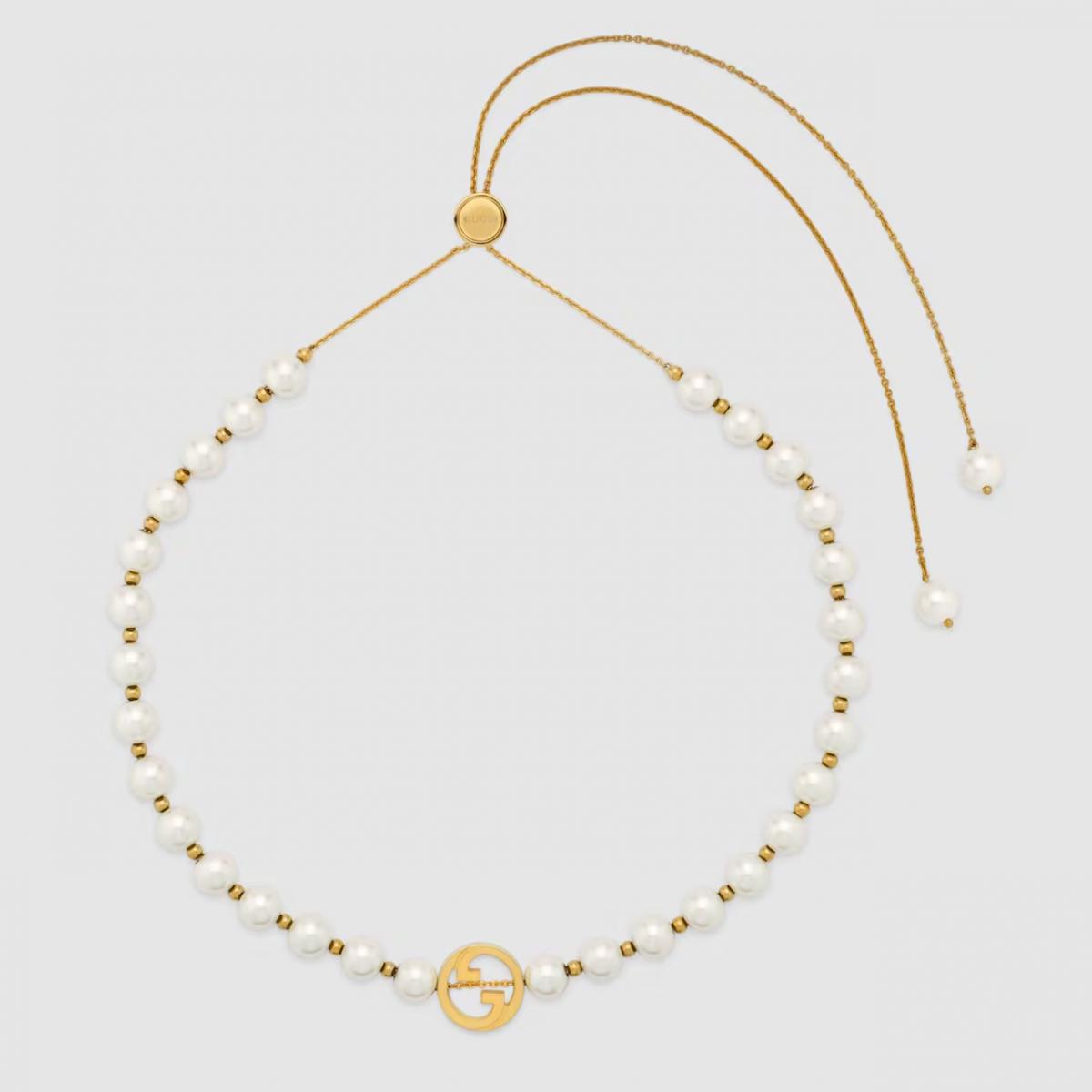 Gucci Interlocking 系列樹脂珍珠項鍊，以淺金色調黃銅搭配鏤空雙G吊墜，將品牌經典符號化為閃爍的藝術語言。新款珠鍊設計讓整體更顯年輕活潑，搭配按鈕滑扣使用便利。它不僅是一條飾品，更像一種態度：在每個細節裡，都能看見對自我風格的堅持。