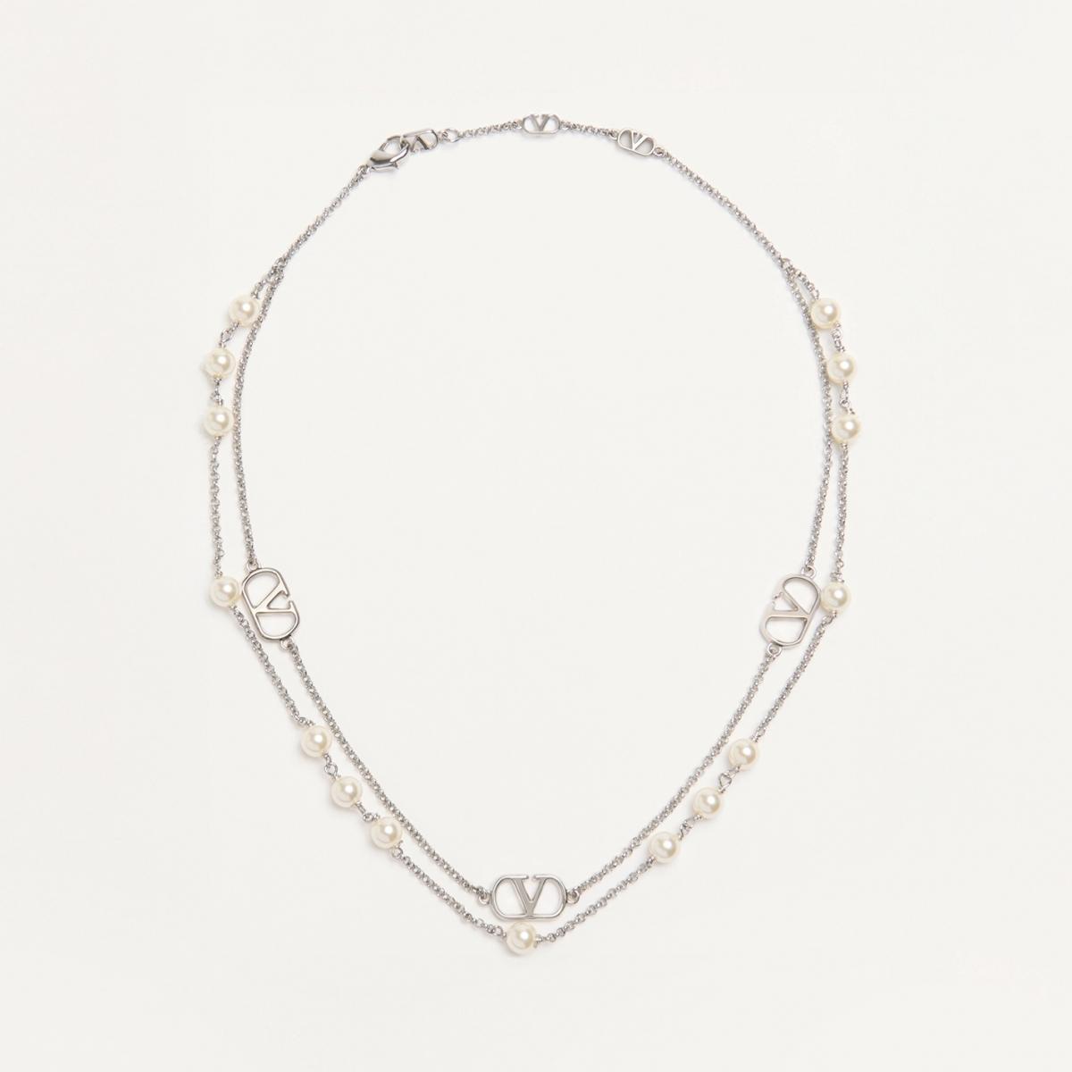 華麗與柔美之間的平衡，是 Valentino 的拿手絕活。這款 VLogo Signature 項鍊以鍍鈀金屬鍊條搭配樹脂珍珠，兩條項鍊可獨立佩戴或交錯疊搭，如雙重旋律，為造型注入戲劇張力。珍珠的溫潤讓金屬更顯柔和，而 VLogo 的銳利線條又為整體增添現代感。無論是搭配毛衣或襯衫領口，都能打造時髦又溫柔的氣場。