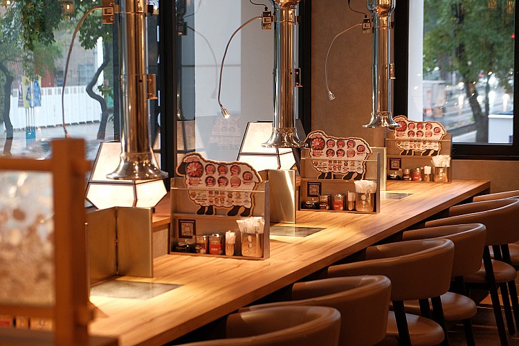 首間海外旗艦店選址於人潮匯聚的中山區，延續旭川本店的精神，以日式氛圍結合現代設計，打造出宛如劇場般的用餐場域。