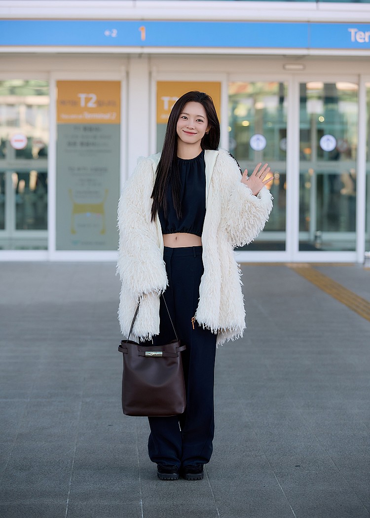 面對冬季尾聲的氣候轉換，金世正選擇以一件Longchamp人造皮草連帽大衣作為整體造型的主軸。象牙白色調搭配蓬鬆長毛質感，視覺上柔軟卻不厚重，不僅具備保暖機能，也自然拉出高級感輪廓。