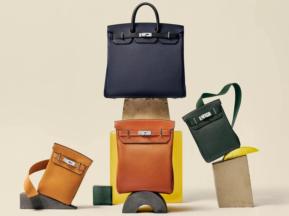 如果是愛馬仕的鐵粉，那對於「Haut à Courroies」這款包一定不生！該包款問世於 1892 年，是品牌最早推出的包袋，同時也被許多人認為是柏金包（Birkin）與凱莉包（Kelly）的原型，該包款碩大的空間，以及硬體的線條，讓它成為許多人旅行、通勤的首選，而在近期其系列包袋亦發展出多種包型，其便利性更符合當今都市人的使用情境。