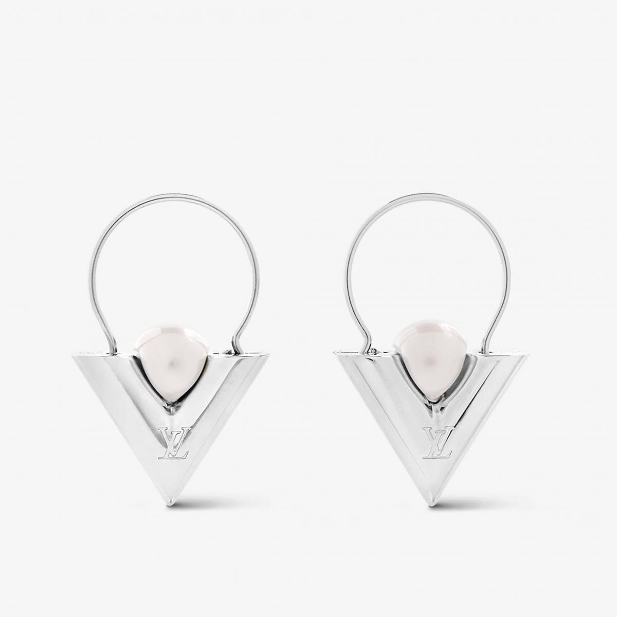 LV 的 V For Vuitton Pearl And Metal 珍珠耳環走的不是典雅路線，而是品牌創意總監 Nicolas Ghesquière 最擅長的「現代女性輪廓」。倒三角 V 字造型以鈀飾面金屬打造，像是為臉部勾勒出俐落框架；中央鑲嵌亮澤樹脂珍珠，柔與剛之間達到完美平衡。上方刻有 LV Initials 經典標誌，使整體更添收藏價值。佩戴起來不僅拉長臉部線條，也能在極簡穿搭中注入剛剛好的時尚感。想讓日常造型不無聊？這對耳環負責替你開場！