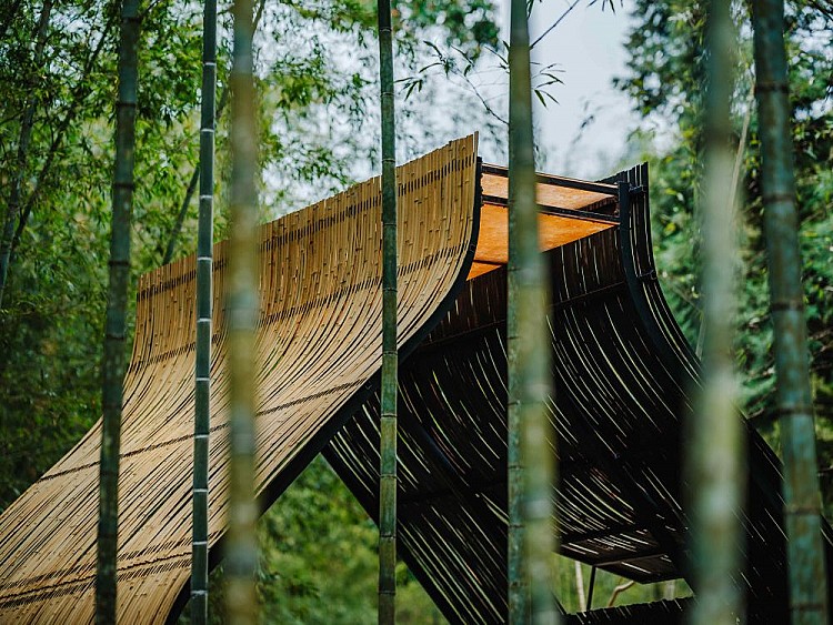 這間小竹屋的造形靈感來自於傳統包粽子的動作，將兩片竹葉鋪在手心、裝入餡料，竹葉因為餡料的重量和手的形狀自然彎曲，逐漸形成包覆的彎曲線條，宛如大自然的藝術品，極其細膩。