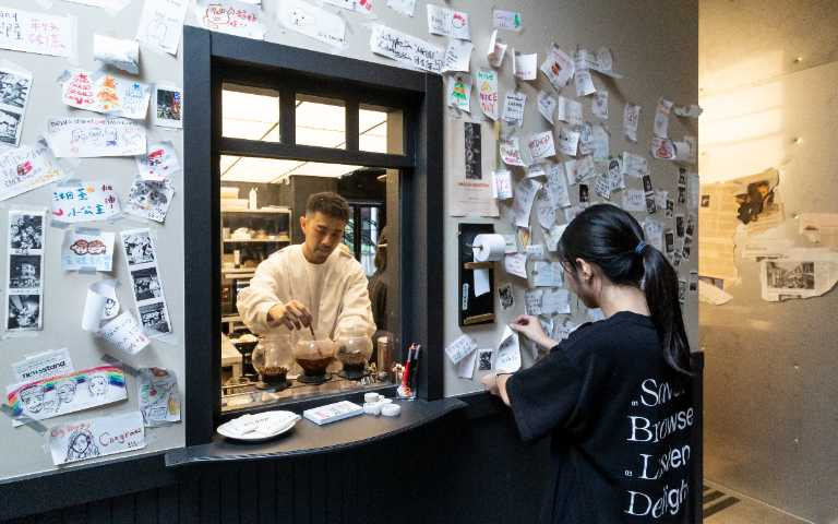 一入店便可看到設計成歐洲老地鐵站的長廊與售票窗口，一旁的紙捲還可以撕下、自由留言。（圖／楊澍攝）