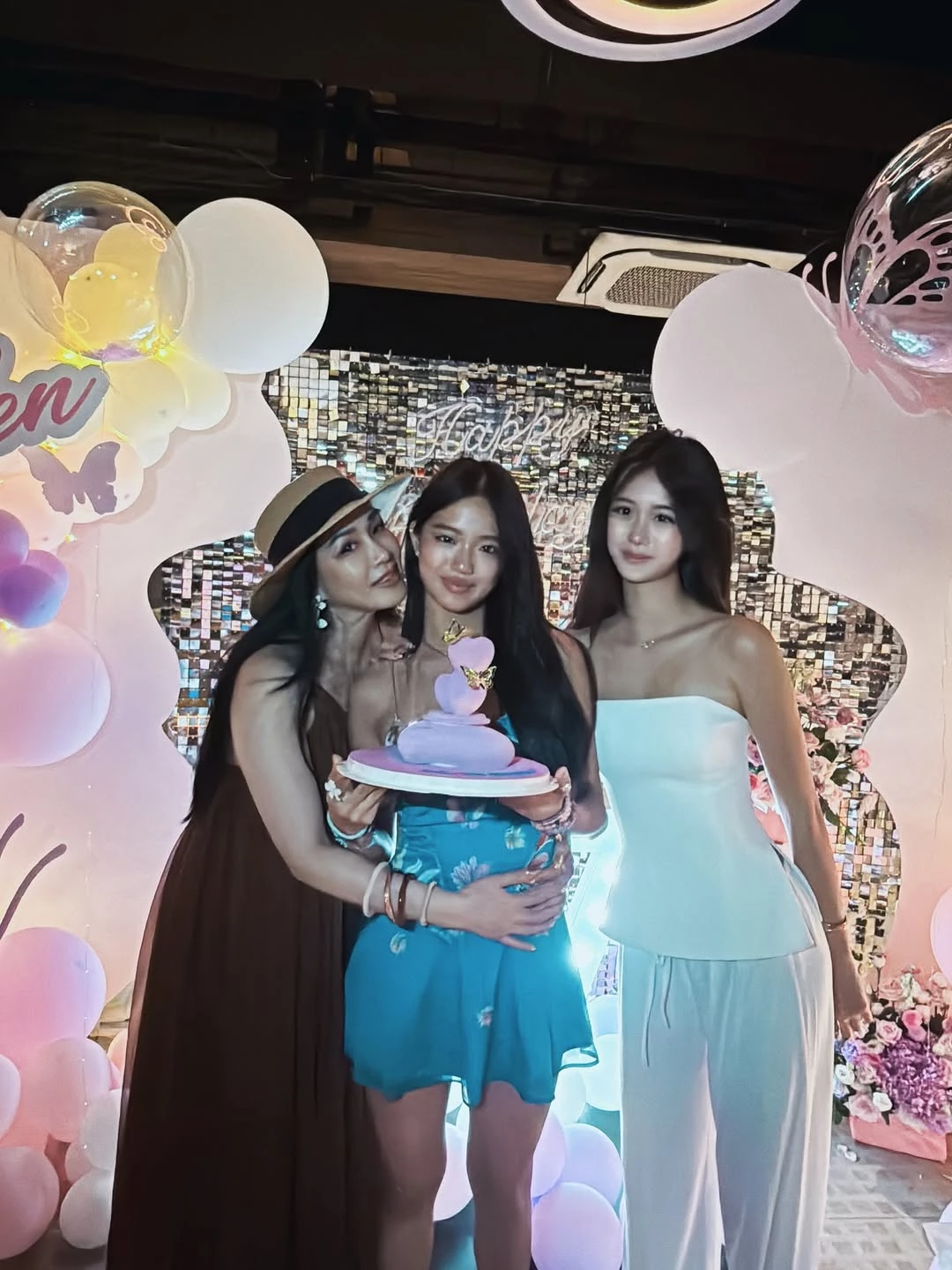 在生日派對場合，Jaden 與 Cayla 不約而同把焦點交給「洋裝本身」。一人選擇貼身剪裁、清楚收腰的水藍印花短洋裝，線條俐落，直接勾勒出高腰位置；另一人則以純白平口上身搭配同色系高腰寬褲，透過腰線上移與褲管垂墜，拉長下半身比例。兩套造型都刻意避免多餘裝飾，色彩與材質維持純粹，讓視線自然集中在肩頸與腿部線條。配件低調不搶戲，使整體輪廓更顯乾淨。這種穿法不僅顯腿長，也讓正式場合的造型看起來從容有餘，是派對穿搭中最穩妥、也最耐看的顯高策略。