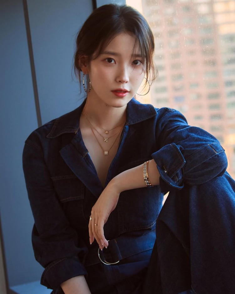 IU以深色牛仔襯衫套裝展現簡約又不失氣場的造型魅力。俐落的剪裁勾勒身形線條，腰間皮帶收出比例，讓整體更顯幹練。她