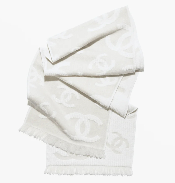 Chanel以淡米色與乳白色交織出經典雙C Logo的優雅層次，輕鬆俐落的輪廓結合絲緞絲巾設計，巧妙融入航海精神元素與細緻亮澤質感，於低調中展現閃耀細節，勾勒出精緻而不失從容的優雅穿搭風格。