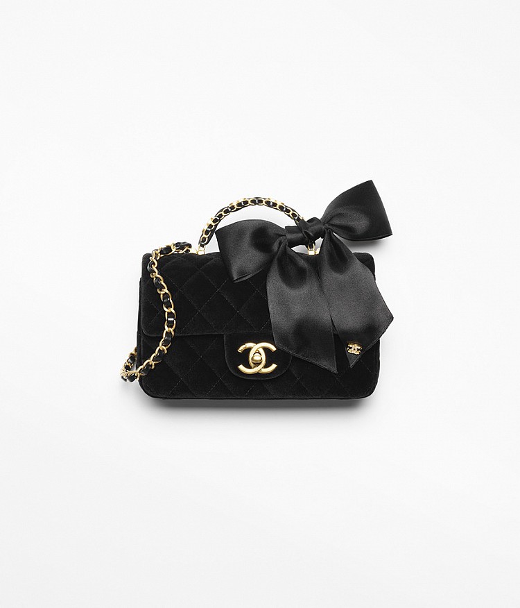 這款經典掀蓋包以絲絨面料呈現，並在皮穿鏈的背帶上裝飾一只絲緞蝴蝶結，全黑的包款藉由不同材質的碰撞，呈現出極具層次的效果。