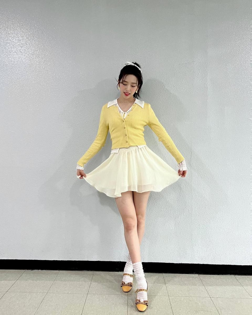 IVE 隊長安俞真，在一次活動中，用白色裙裝外罩黃色開襟針織衫穿出甜美可愛的氣質！