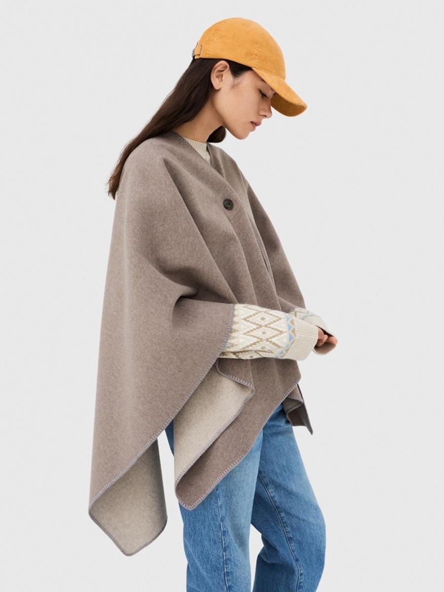 想在秋冬造型中穿出一點風格轉折？這款斗篷外套正是時髦與實穿兼具的代表。以柔軟親膚的布料製成，穿起來輕盈卻具保暖度，內裡採對比色設計，並以明顯車縫線強調結構線條，讓整體更有層次感。