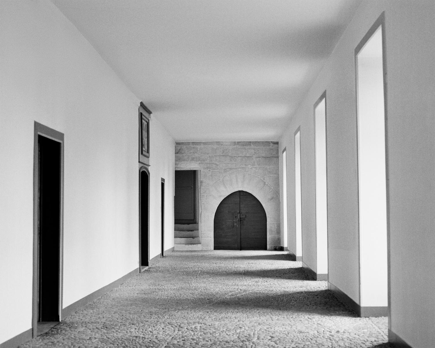       香奈兒女士兒時待過6年的奧巴辛（Aubazine）修道院一隅。  延伸閱讀：重現香奈兒女士首個珠寶創作！《Plume de Chanel》將羽毛化作配飾：擬真姿態輕柔似水，呈現剛柔並濟之美    香奈兒故事 2： Coco 不是真名    值得一提的是，世人所熟知的「Coco」並非香奈兒女士的本名，她真正的名字是 Gabrielle Chanel 嘉柏麗香奈兒。至於 Coco 的由來，說法眾多，最廣為流傳的一種版本是，她年輕時曾在咖啡館駐唱，常演唱歌曲 〈Qui qu’a vu Coco〉，觀眾便熱情呼喊「Coco！Coco！」，久而久之成了她的外號；也有人認為這是法語 Cocotte（小甜心）的縮寫，或是父親給她的暱稱。但無論真相如何，這個名字後來都與她緊緊相連，不僅成為她的另一個稱號，更隨著品牌傳遍全球，成為時尚史上最響亮的符號之一。  延伸閱讀：Chanel 2025 高級腕錶寫下「女人之書」！以香奈兒藍、化妝品粉、獅子金演繹時間三幕劇    香奈兒故事 3： 從帽子設計師起家   香奈兒女士在康朋街31號鏡梯上留影，羅伯特·杜瓦諾（Robert Doisneau）攝於1953年。  在被稱為時尚女王之前，香奈兒不過是巴黎街頭的一名年輕帽商。1910年，她在康朋街21號開設了第一間帽子店 「Chanel Modes」，只販售她設計的簡潔帽款。當時的流行仍是華麗誇張的羽毛與花卉帽飾，幾乎像頭上的「裝飾雕塑」，但她卻反其道而行，以乾淨俐落的線條展現不費力的高雅，這股清新之風很快打動了巴黎上流社會，也讓她嶄露頭角。隨著事業發展，她在1918年將店鋪擴張至康朋街31號，這裡不僅販售完整的時裝系列，更成為 Chanel 的標誌性旗艦店，樓上還有她的私人寓所與著名的鏡面旋轉樓梯。這段從21號到31號的進階，不只是地址的轉換，更象徵她從帽商蛻變為時尚帝國締造者的關鍵一步。       位於康朋街31號的香奈兒精品店，由泰瑞瑟邦妮（Thérèse Bonney）攝於1929年。  延伸閱讀：築夢踏實！2025香奈兒《Reach For The Stars》頂級珠寶，給女人一對翅膀飛翔    香奈兒故事 4： 解放女性身體束縛    香奈兒女士與名流好友攀爬於 La Pausa 故居的一棵樹上，攝於1938年。  20世紀初，女人還困在緊身胸衣與厚重長裙裡寸步難行。香奈兒女士卻一舉打破這道「鐵籠」，她從男裝汲取靈感，改用針織布、粗花呢等舒適布料，設計出既能自在行動、又不失優雅的服裝。1913年，她在多維爾（Deauville）開設時裝店，正逢第一次世界大戰爆發，女性大舉走入職場與戰場，她的「實用主義時裝」瞬間成為全歐洲的風潮。最具代表性的「斜紋軟呢」套裝，更徹底顛覆了傳統，讓女性能自如行走。這場以布料為武器的革命，不僅讓身體重獲自由，也象徵女性精神真正的解放。  延伸閱讀：Chanel香奈兒「N°5高級珠寶」全新登場！6大亮點解碼：香水如何具象化？    香奈兒故事 5： 讓小黑洋裝成為經典   香奈兒女士慵懶倚靠在躺椅上，霍斯特·P·霍斯特（Horst P. Horst）攝於1937年。  在1920年代之前，黑色幾乎只屬於哀悼與沉重的場合。但香奈兒女士大膽翻轉了這種印象，推出簡約俐落的「小黑洋裝」（Little Black Dress, LBD），證明黑色同樣可以性感、優雅，甚至比繽紛色彩更耐看。1926年，美國時尚雜誌刊登了她的設計，並形容它是「a sort of uniform for all women of taste」（所有女性的制服），讓黑色瞬間從陰鬱的象徵，變成洗鍊且百搭的時尚密碼。這種理念也延伸到她的經典套裝：裙裝搭配剪裁精準的外套，再加上一串珍珠項鍊，無論白天或夜晚都能游刃有餘。時至今日，小黑裙依然是全球女性衣櫥裡最不可或缺的永恆單品，也是一種屬於 Chanel 的優雅態度。    香奈兒故事 6： 解放雙手的2.55包款   香奈兒女士穿著簡潔套裝，搭配珍珠項鏈，手邊擺著一只2.55包款。  如果說斜紋軟呢套裝讓女性能自在行走，那麼「2.55」包款則徹底解放了女性的雙手。1955年2月，Chanel 推出這款帶有鍊帶肩背設計的包款，命名即取自誕生的年份與月份。當時女性普遍仍手拎手袋，顯得不便，她卻大膽在包款上加上金屬鍊帶，讓女人能把包斜背在肩，雙手得以自由應付生活。柔軟的菱格紋皮革，靈感源自馬術世界的馬毯；內襯則選用勃艮第紅，據說致敬她童年寄宿的修道院服裝。這款既實用又優雅的設計，自誕生以來便成為經典，象徵的不只是時尚配件，更是一種讓女性真正獨立、自主的生活態度。  延伸閱讀：Chanel 經典口蓋包怎麼選？香奈兒 2.55、11.12、方胖子，規格、尺寸一篇搞懂，銷售員說的「CF包」原來是這款！    香奈兒故事 7： No. 5 的幸運數字   N°5 香水的八角形瓶蓋設計，靈感來自巴黎芳登廣場（Place Vendôme）。  香奈兒女士不僅改變了服裝，也徹底顛覆了香水世界。1921年，她與調香師 Ernest Beaux 合作推出 Chanel No. 5。為什麼是「5」？因為她深信這是她的幸運數字，她的時裝發表選在5月5日，而當 Beaux 拿出多個樣本時，她毫不猶豫就挑選了第5號。這款香水不僅香氣前所未見，其方正俐落的瓶身更徹底打破當時繁複的香水瓶設計，以簡約之姿成為永恆經典。到了1950年代，瑪麗蓮夢露一句經典回答：「What do I wear in bed? Why, Chanel No. 5, of course.」（我睡覺時只穿 No. 5），更讓這瓶香水一舉成為性感與奢華的代名詞。直至今日，全球平均每30秒就售出一瓶 No. 5，讓「數字5」從此與 Chanel 緊緊相連，成為永不褪色的符號。  延伸閱讀：30歲女人值得擁有一只香奈兒名錶！「Chanel Première 原創款腕錶」穩坐女人心中「夢幻錶款」地位的5大理由    香奈兒故事 8： 讓「曬黑」成為時尚   香奈兒女士於 La Pausa 故居的薰衣草花園裡，攝於1938年。  除了在服裝風格上具備影響力外，香奈兒女士的生活風格也備受矚目。在過往年代，白皙肌膚被認為是上流社會的標誌，而黝黑膚色則被視為勞動階層的標記。然而到了1920年代，當她在蔚藍海岸度假時，因日曬而呈現出一身健康的小麥色肌膚，沒想到立刻掀起名媛們的爭相效仿。從那一刻起，「曬黑」不再代表勞作，而是轉化為閒適、優雅與時尚的符號，甚至被視為富裕階層悠閒生活方式的象徵。這個看似偶然的瞬間，卻成了全球審美的分水嶺，也再一次證明 Chanel 的影響力遠遠超越服裝設計，她真正做的，是重新定義了「時髦」本身。    一代時尚傳奇：Coco Chanel   香奈兒女士穿著優雅黑色套裝，搭配經典珍珠項鍊與珠寶首飾，由攝影師曼雷（Man Ray）攝於1953年。  從帽飾到香水，從服飾、包袋到日曬美學，香奈兒女士一生都在挑戰傳統、顛覆規則，她是矛盾卻璀璨的傳奇。出身平凡的她，卻締造了世界頂尖的時尚帝國；她選擇不婚，卻在感情世界裡留下無數段傳說。1971年，她在巴黎麗茲酒店（Hôtel Ritz Paris）安然辭世，享壽87歲。墓碑上雕刻著五顆獅子頭，正如她的獅子座性格，象徵力量與自信。或許她的人生並不完美，卻因不斷挑戰界限，改變了女性與時尚的關係。她從不只是設計師，而是一場屬於女性的革命，她留給世界的，不僅是一個品牌，更是一種將自由、優雅與叛逆融合的生活態度。    無論時間過了多久，我們還是想向這位時尚傳奇說聲：生日快樂！    香奈兒常見問與答   香奈兒女士於 La Pausa 故居，攝於1938年。  Q1：為什麼 Chanel No. 5 能紅超過百年？ A1： 因為它不只是香水，而是一種態度。No. 5 首度把多種花香融合，做出當時前所未有的「抽象香氣」，瓶身設計更是極簡俐落，和當時繁複的香水瓶完全不同。再加上瑪麗蓮夢露一句「我睡覺只穿 No. 5」，它立刻成為性感與奢華的象徵，至今仍是香氛界無法撼動的傳奇。    Q2：小黑裙為什麼被稱為「所有女性的制服」？ A2： 因為它能「一衣百搭」，白天穿可以簡約幹練，晚上加上珍珠或紅唇，又能變身華麗性感。1926 年《Vogue》就說過，小黑裙會像一輛福特汽車一樣普及。它代表的是「少即是多」的精神，至今依然是每個女人衣櫥裡的安全牌。    Q3：為什麼 Chanel 一直強調「簡單」？ A3： 她自己說過：「奢華必須是舒適的，否則就不是奢華。」在那個女人被緊身胸衣綁住的年代，她的設計讓女性能自在呼吸、自由行走。她認為簡單不代表無聊，而是最純粹的優雅。也正因如此，她才能把「自由」縫進每一件衣服裡。    Source: Chanel    加入Bella  LINE@ ，成為儂粉每周五抽時尚小禮    走進香奈兒女士靈魂深處！達利與畢卡索都曾駐足的La Pausa故居，百年後優雅重生 Chanel香奈兒「N°5高級珠寶」全新登場！6大亮點解碼：香水如何具象化？ 2024香奈兒旗艦腕錶登場！6大精髓解析：會動的 Coco Chanel 微型機械動偶藏家搶著要，粉紅 J12 數量稀有 Chanel 2025 高級腕錶寫下「女人之書」！以香奈兒藍、化妝品粉、獅子金演繹時間三幕劇