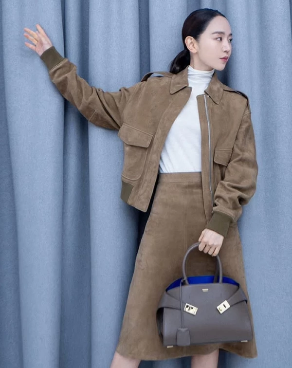 申惠善再次展現她作為時尚指標的多面魅力，尤其她與Ferragamo的精彩演繹更成為焦點。身穿成套麂皮套裝的她，以柔和卻俐落的線條勾勒出知性氣質，手上拎著品牌近年話題度極高的「Hug」包款系列，為整體造型注入畫龍點睛的一筆。