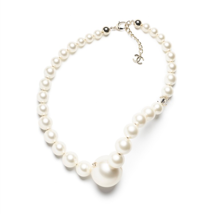 以大小錯落的的圓潤珍珠串聯而成，宛如項鍊般斜掛於身上，瞬間成為全場目光焦點。