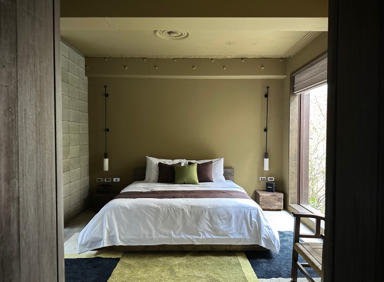 「蔚南裏」房型內大面開窗引進自然綠意與光線，牆上綠磚與地毯呼應，搭配木質傢俱更顯古都沈靜氣息