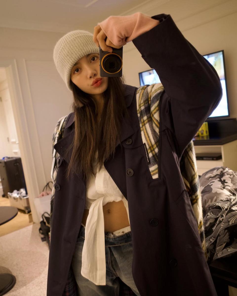 以暖色系為延伸，這套搭配裡 Lisa 以棕紅色大衣為主角，並在配件上運用暖粉、燕麥色做搭配，讓整體色系呈現出溫暖又和諧的樣貌，同時在配件的堆疊下又極富層次感。