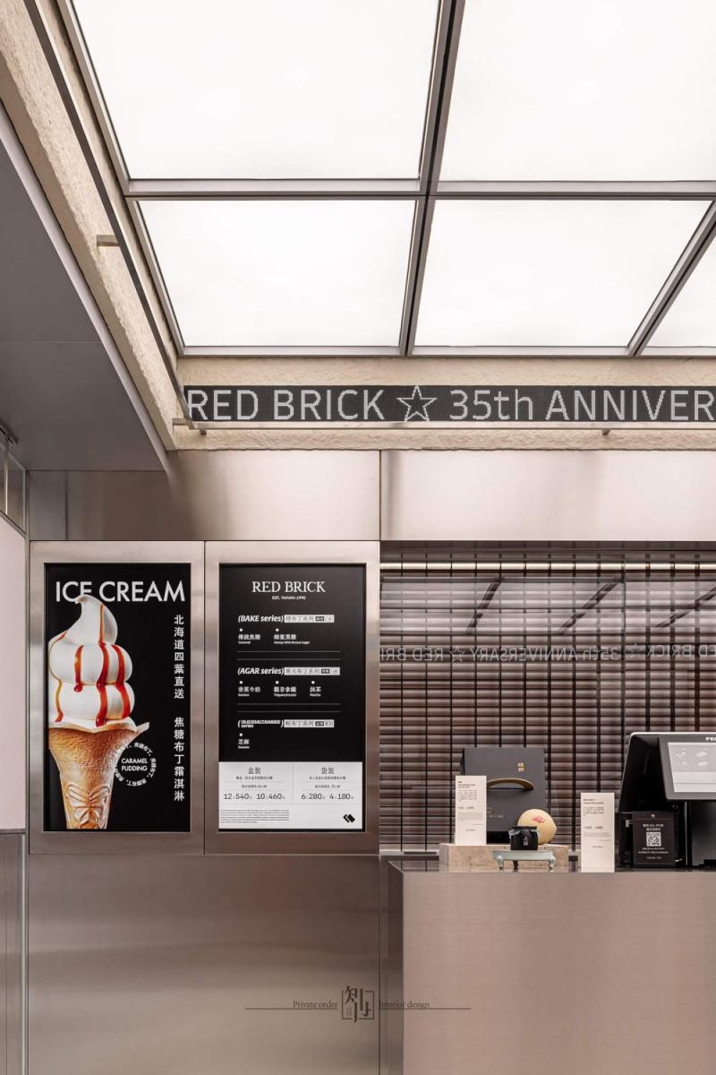跳脫既定的甜點店形式，Red Brick 找來「知冉設計」操刀空間設計，透過大面積紅磚語彙作為主視覺調性，運用窯燒立磚鋪陳牆面，轉譯台南獨有的磚牆歷史溫度。在充滿溫暖意象之餘，也大量揉入不鏽鋼材質，並活用於櫃體、牆面與細節裝飾中，營造冷冽俐落的未來感。這個充滿現代工業風格的空間，在溫暖與冷酷之間，取得了適切的視覺平衡美學。