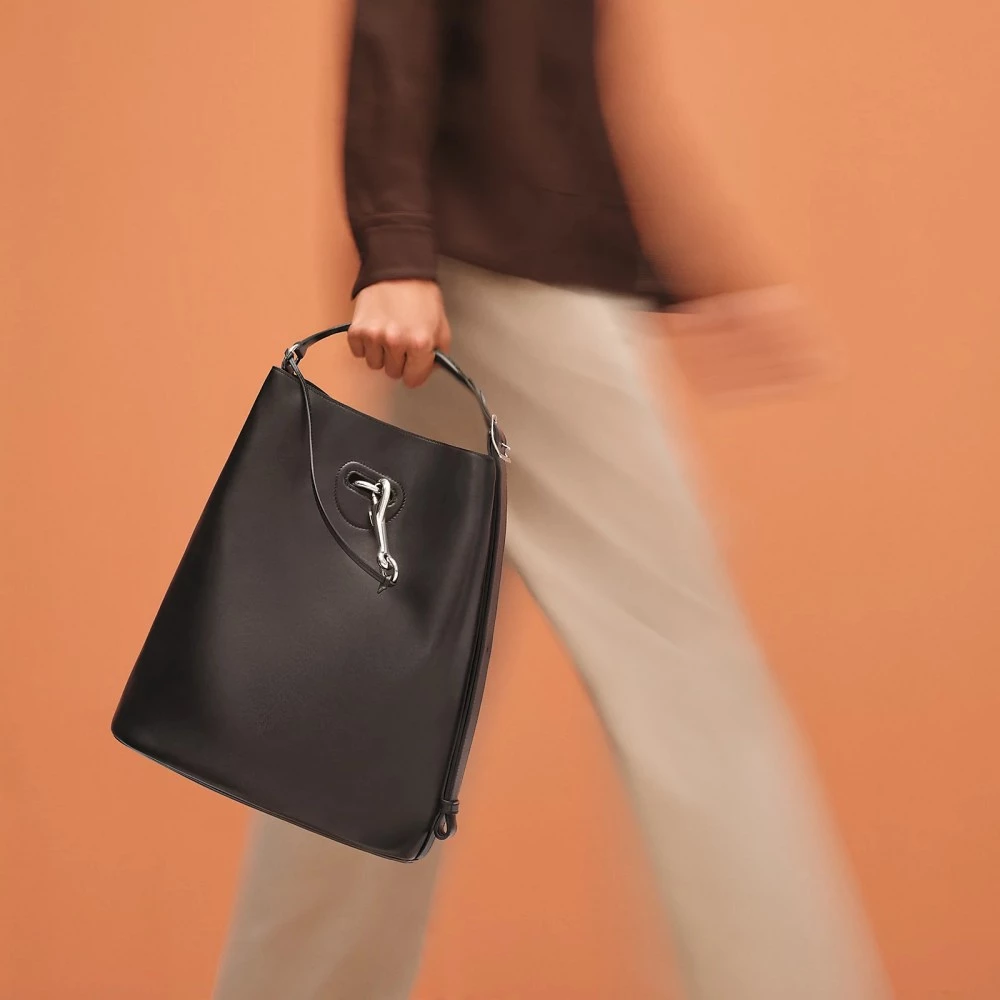 另一只話題包款名為「Seau Mousqueton」，該包袋是歸類於男裝系列中，其包身以柔軟的皮革為基礎，以類似流浪包的形式呈現出隨性的姿態，而包身上僅以一只馬鞍扣為點綴，整體極簡又不失個性的設計，是品牌去年度最受關注的包袋。