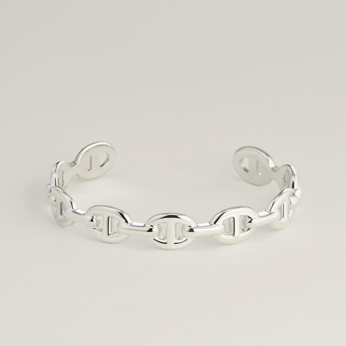 這條手鍊可以說是 Hermès 珠寶世界裡最具「雕塑感」的一款作品。相較於傳統錨鍊的柔軟流動，Enchaînée 系列刻意顛覆原有的靈活特性，將鏈節轉化為立體、厚實、彷彿被凝固的金屬結構。佩戴在手腕上，它不像裝飾，更像一件貼身的現代雕塑，線條乾淨、比例精準，卻藏著極高的工藝密度。1937年 Robert Dumas 在布列塔尼海岸觀察船錨時所捕捉到的力量感，在此被重新放大，轉化為極具存在感的當代設計。這款手鍊非常適合日常單戴，不需疊加其他飾品，就能自然形成風格重心，是一件低調卻極有態度的愛馬仕代表作。