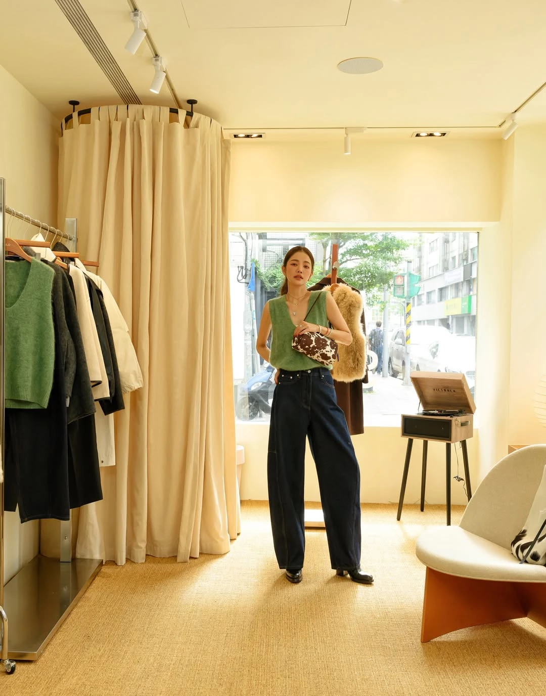 想把日常造型穿得有個性，其實不一定需要太多複雜單品，重點在於材質與圖案的搭配。許路兒以上海設計師品牌 Slo 的綠色毛毛背心搭配深色丹寧褲，透過柔軟的針織材質帶出輕盈感，也讓整體色調多了一點自然氣息。V 領背心能修飾肩頸線條，而直筒牛仔褲則保留丹寧的率性輪廓，既舒適又有俐落感。腳下搭配黑色短靴，使整體比例更加修長，也為造型增添一點成熟的都會氣質。與服裝同品牌的 Toast Bag 吐司包，以極簡長方形輪廓搭配天然牛皮打造，最吸睛的設計是帶有乳牛紋理的毛皮材質，讓整體造型多了一點趣味與個性。包型修長、線條簡潔，非常適合日常搭配，也能替簡單穿搭增加視覺焦點。當服裝保持乾淨俐落時，一只具有圖案特色的包款往往就能成為整體造型的亮點，讓日常穿搭看起來更有風格。