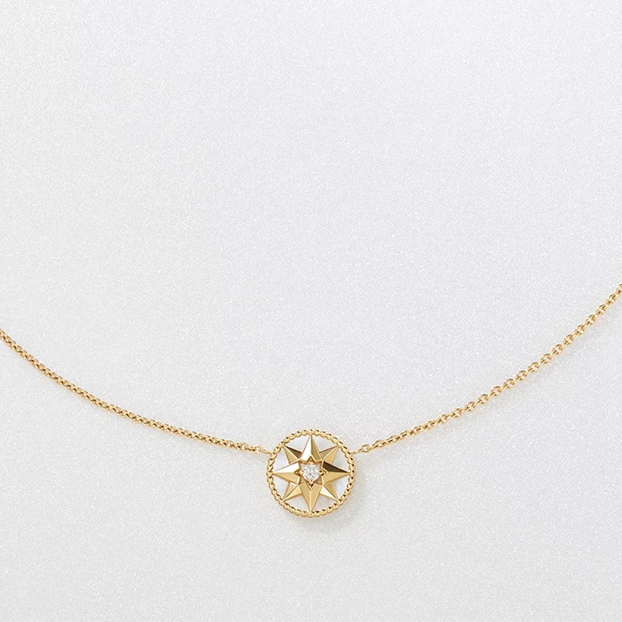 一枚能旋轉的羅盤吊墜，將冒險精神和幸運星融合為一。珠寶設計師 Victoire de Castellane 以迪奧先生鍾愛的幸運星為靈感，將八芒星造型以18K黃金、鑽石與珍珠母貝演繹，創造出 Rose des Vents 系列。