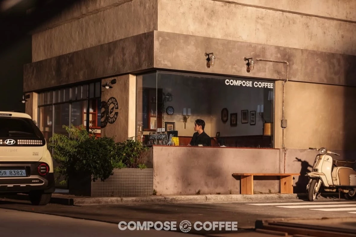 韓國咖啡品牌 Compose Coffee 最早於 2014 年在釜山成立，自創立以來便以平價又好喝的咖啡迅速打入韓國民眾日常消費市場，這家咖啡廳主打大杯、高品質、低價格，讓忙碌的學生、上班族與通勤族每天都把它當成「續命解藥」，成為韓國街頭最常見的外帶咖啡品牌。因為超高 CP 值與高品質也讓 Compose Coffee 迅速擴張，到 2025 年全國門市已突破 3,000 家。