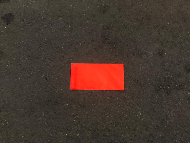 拿著紅包袋對著天空，專注冥想「鈔票如雨落下」的畫面