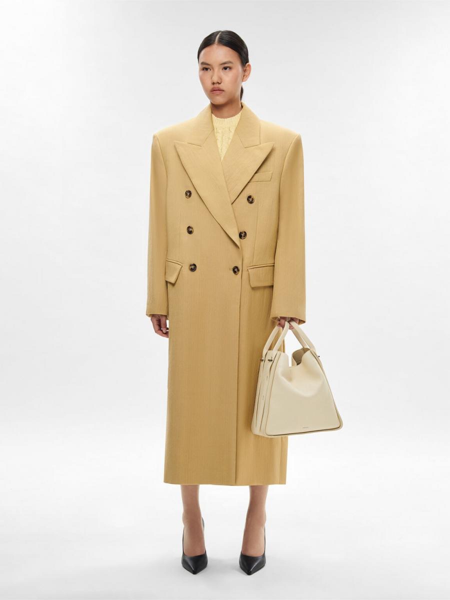 說到百搭的通勤包款，Pedro「Demi」水桶包絕對是首選之一。以小牛皮壓紋皮革打造，包身立挺卻不厚重，梯形輪廓、寬肩帶設計，視覺上顯得更俐落。