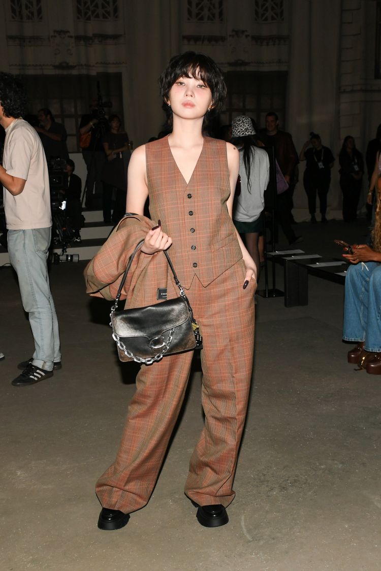 Coach大秀星光熠熠，其中最受矚目的莫過於韓團i-dle隊長田小娟。她以一身棕色格紋無袖背心與寬版長褲套裝亮相