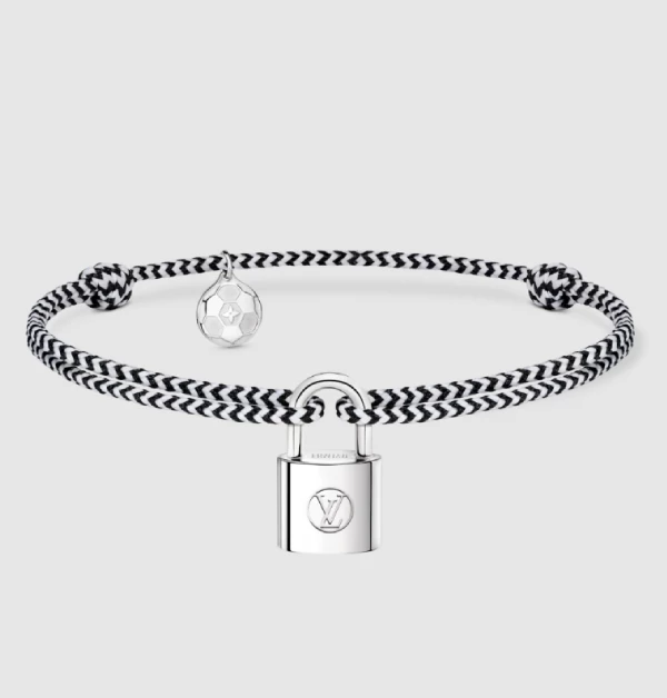 LV「Silver Lockit」這次特別換上黑、白相間的編織繩手環，視覺上多了幾分賽車格紋般的流暢與酷勁，最讓人驚喜的，莫過於鎖頭旁那顆精緻微縮的純銀足球吊飾，上面還細細刻劃著品牌標誌性的品牌Monogram花紋，瞬間點亮了整體的運動時尚感。（商品價格約：NTD 11,600）