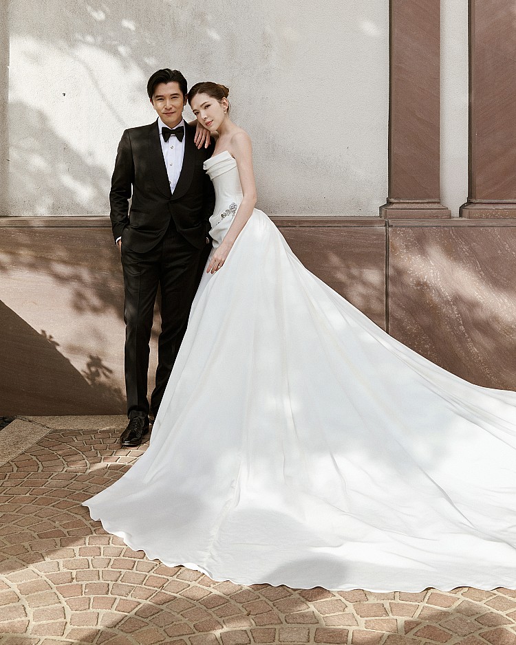 許瑋甯今日穿上Nicole + Felicia訂製的白紗亮相，以優雅線條與戲劇張力完美驚豔全場，婚紗細節也立即引發網友熱議。主禮服以柔霧象牙白為基底，特別選用帶有溫潤米調的面料，更貼合許瑋甯的膚色。上身以立體摺襇修飾肩頸線條，搭配乾淨俐落的雕塑腰身，高貴且優雅的魅力讓人眼睛離不開。