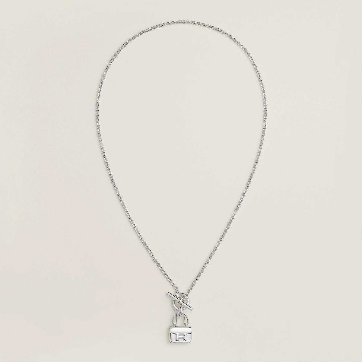 Amulettes 系列將愛馬仕經典包款化為「護身符」般的珠寶存在，而 Constance 墜飾正是其中最具代表性的一款。H 形釦環被縮小、提煉，轉化為純銀墜飾，保留原本俐落的幾何比例，卻多了一份貼近身體的溫度。搭配可開合的釦環設計，讓佩戴方式更具彈性，既可單獨作為項鍊焦點，也能與其他吊飾疊搭，展現個人風格。這款作品特別適合喜歡低調識別符碼的人，不需要大聲宣告品牌，卻能在細節中被懂的人一眼認出。