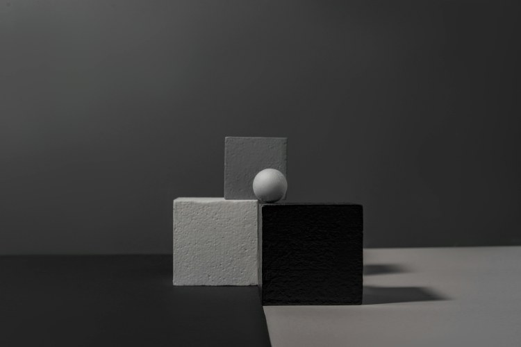 白色球體在各式方柱體上平安擺放著。