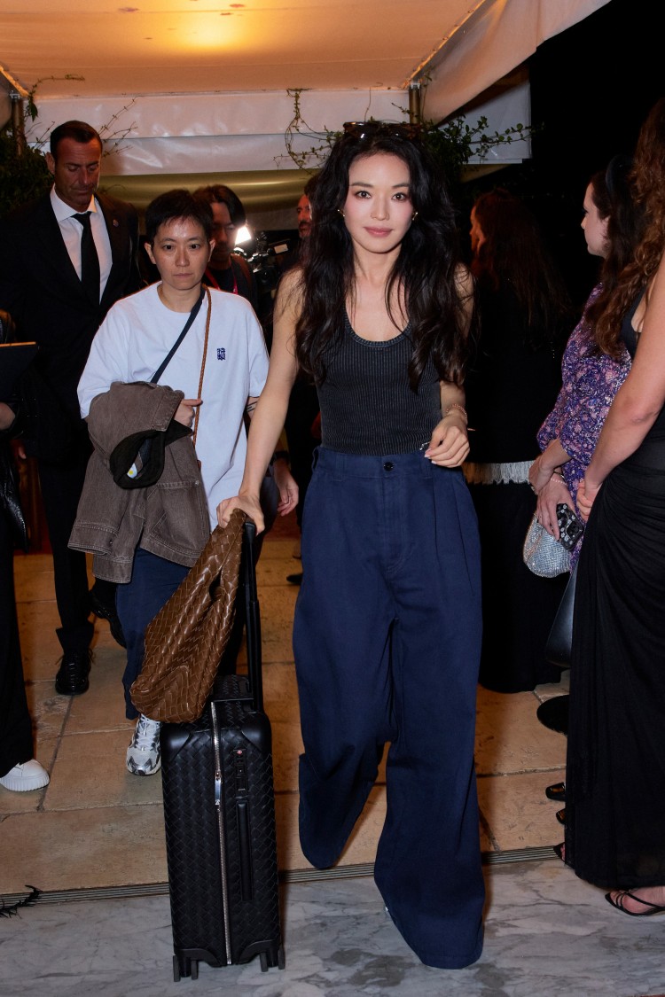 淇更率先以私服示範亮相，以針織背心搭配寬褲，手提焦糖棕Campana與編織登機箱現身威尼斯機場，隨性之中流露從容自信，完美演繹BV女孩的都會魅力。