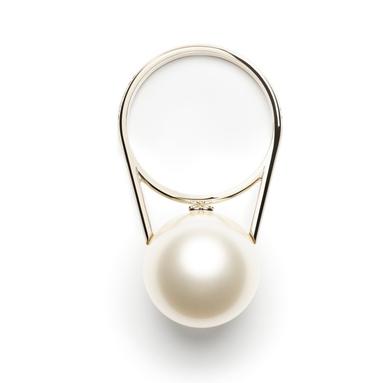 以單顆放大的圓潤珍珠為主體，搭配俐落金屬提把，這款手提包營造極簡卻充滿戲劇性的視覺效果。