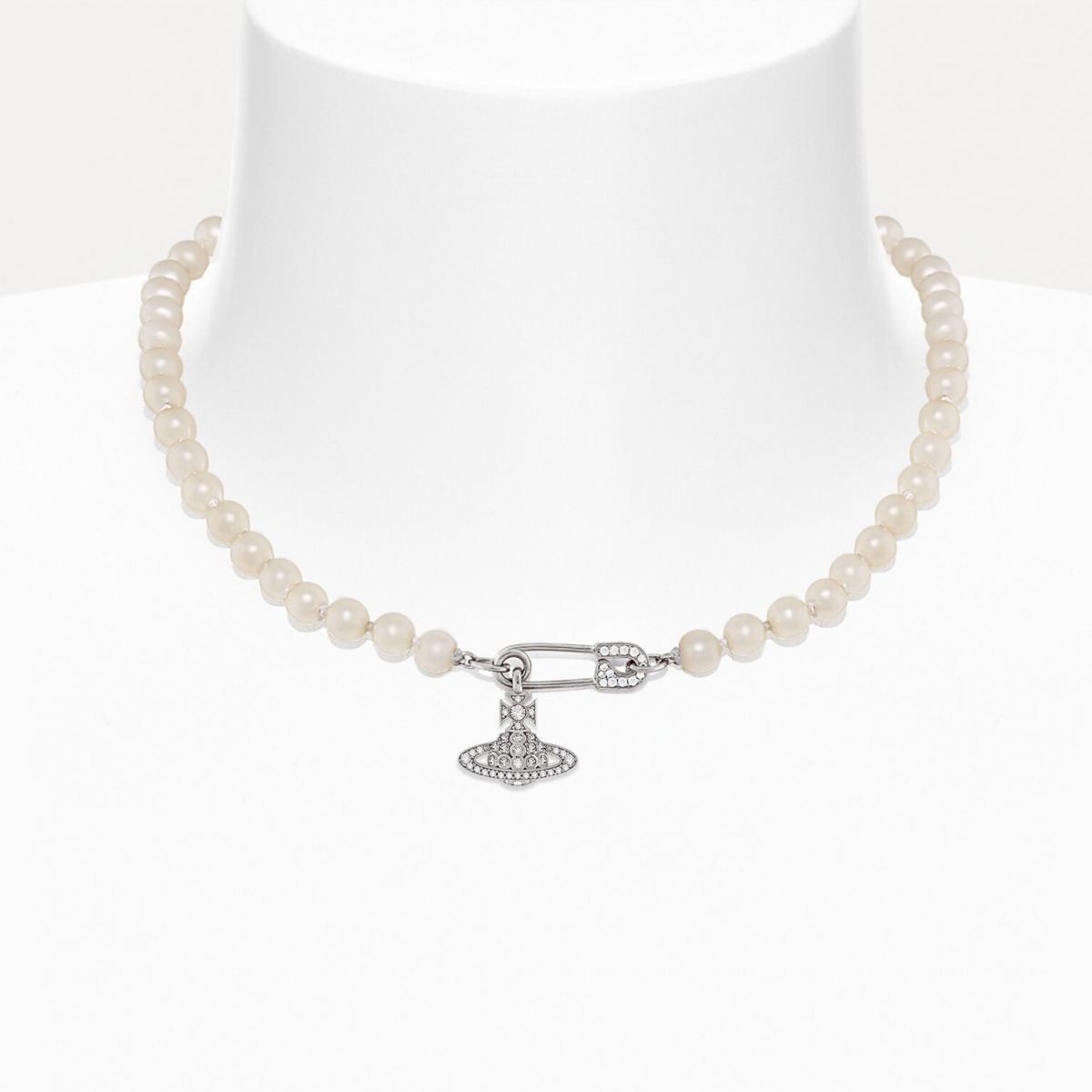 在 Vivienne Westwood 的世界裡，珍珠永遠帶著一點不服從。Lucrece 項鍊以玻璃珍珠串連安全別針吊飾，並綴上鑲水晶的經典土星標誌。這是一條兼具龐克與浪漫的珠寶，彷彿在提醒著我們：優雅不一定要溫柔，也能帶點鋒芒。
