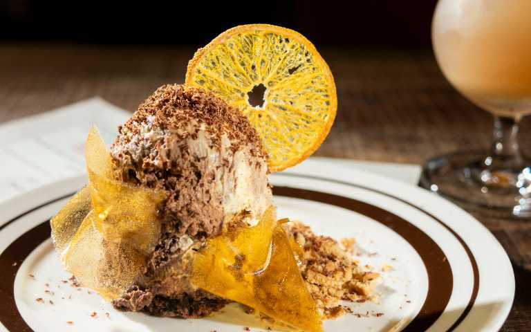 「甘甜交響」像是在口感近似提拉米蘇的蛋糕中加入柑橘香氣，僅用柳橙汁與糖製成的糖片成為最大亮點。（210元，圖／楊澍攝）