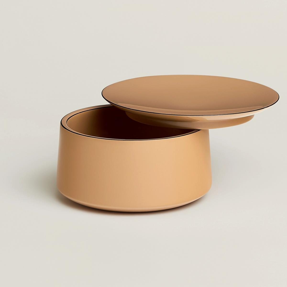 由設計師 Pierre Charpin 打造的 Hemisphere 置物盒，以純手工漆面工藝展現色彩的層次。表面霧化處理，讓灰黃色的色澤既穩重又具現代感，輕易融入各種家居氛圍。