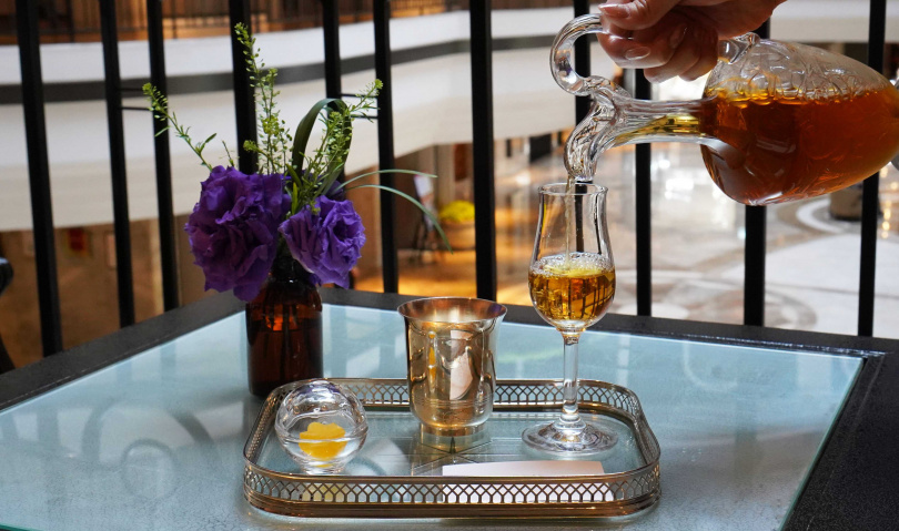 「貴妃烏龍」使用古董醒酒器Marennes盛裝、倒入原本做為威士忌杯的杯款，搭配帶有果香的甜點「托帕石」。（圖／魏妤靜攝）