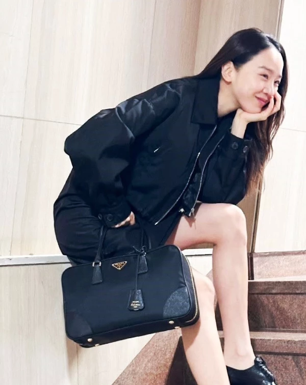 這張穿搭組照片，則是完美展現出申惠善是如何將經典機能與當代摩登完美融合，此款來自Prada的「Re-Edition 1978 」系列復刻版保齡球包包，巧妙致敬了Prada於1978年引領時尚圈的尼龍革命，將耐用的標誌性再生尼龍與細緻的Saffiano皮革細節拼接，在復古輪廓中注入現代感。