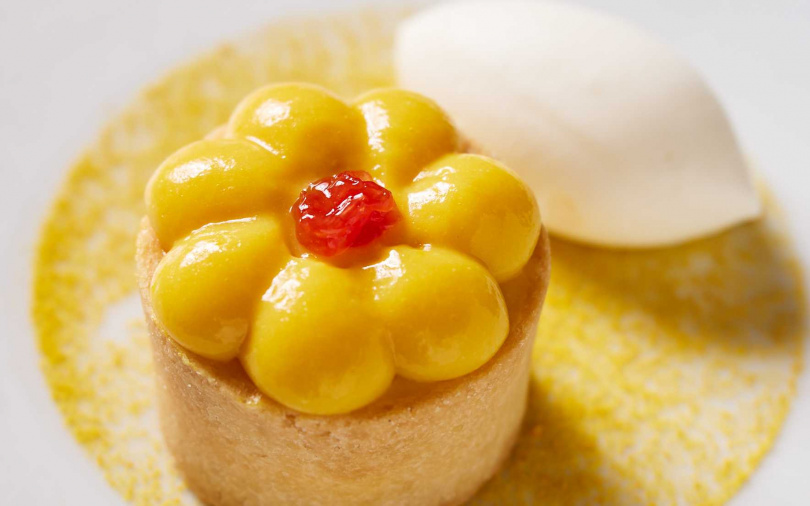 蜜柑塔以金黃塔皮包裹Ricotta內餡，鋪上蜜柑果醬與微苦金巴利蜜柑醬，酸甜平衡、細膩克制，佐以葡萄柚冰與蜂花粉。（圖／三二行館提供）