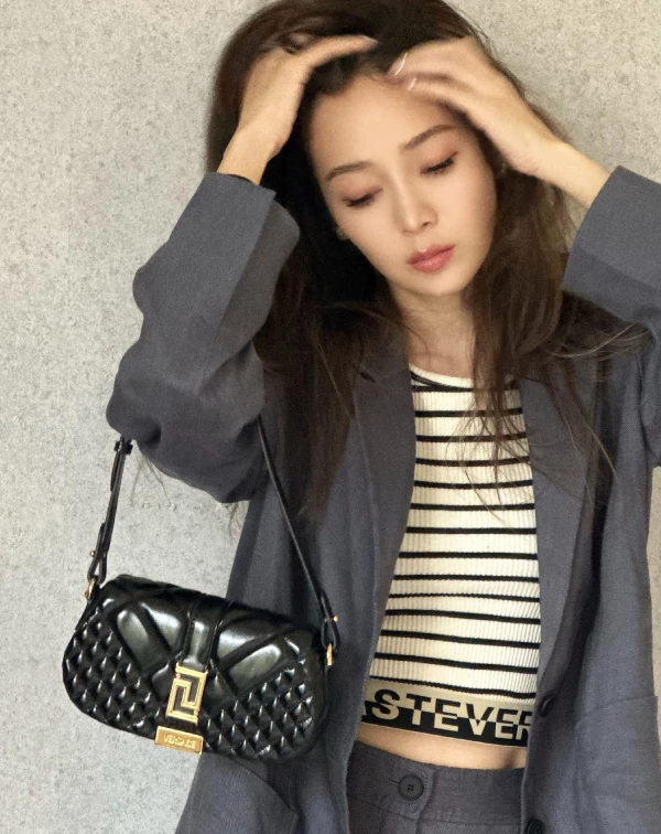原本偏正式、容易顯成熟的西裝，侯佩岑選擇用寬鬆版型去弱化嚴肅感，但真正讓人眼睛一亮的是內搭那件運動風條紋鬆緊上衣，不只拉高腰線、優化比例，還為整體注入一點街頭感，讓西裝外套不再只是端莊，而是多了個性。只要再搭配率性的蓬鬆髮型，或像Versace亮面菱格紋包…這般有存在感的配件或包款，相信就能在成熟與青春之間，取得剛剛好的平衡，輕鬆穿出既高級又有活力的減齡造型。