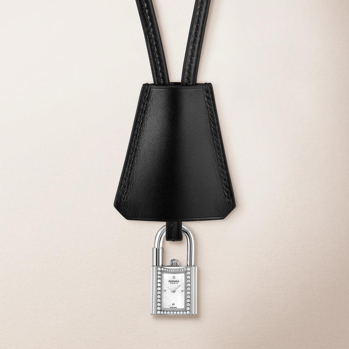 Hermès 的 Kelly 錶是對品牌傳奇手袋的一次巧妙致敬。以鎖頭造型化身為迷你時計，16毫米的精鋼鑲鑽錶殼懸於頸間或繫於腕上，既俏皮又高雅。